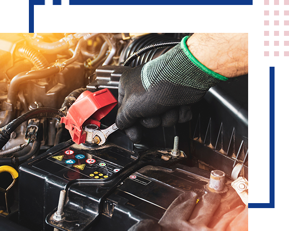 Mechanic holding wrench to repair car battery